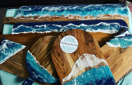 Wooden cutting board with ocean wave design and 'Crafting by the Sea' logo.